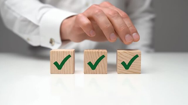 Hand Placing Green Check Mark Wooden Blocks in Bright White Background for Validation Concept, Business Approval, Positive Choice, and Quality Assurance.