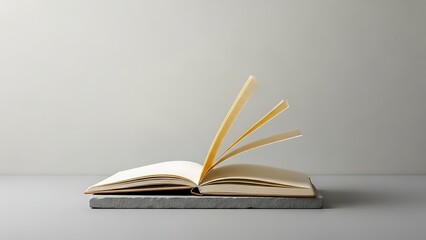 Obraz premium Open book on a gray surface, pages turning.