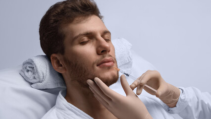 Close-up lip filler injection improving male lip symmetry. Concept of balanced shape correction,...
