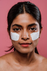  Young woman applying moisturizer on face