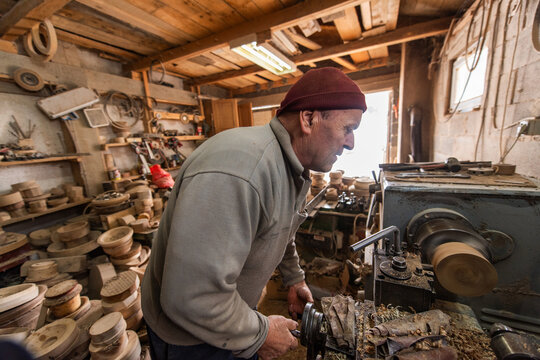 Senior Craftsman Using Wood Lathe Machine in Workshop Woodworking and Carpentry Manual Wood Turning Wood Shavings Crafting