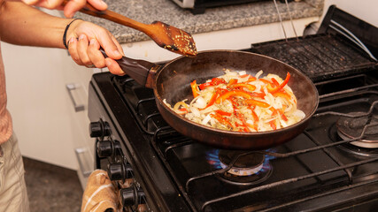 sauteing onion and bell peppers in a frying pan