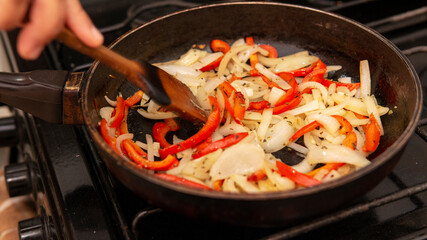 sauteing onion and bell peppers in a frying pan
