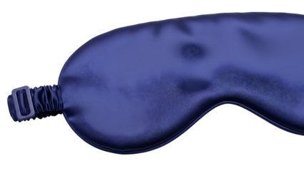 A close-up of a blue silk eye mask, lying on a dark background