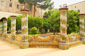 View of the colorful tiled columns of the cloister of Santa Chiara in Naples, Campania, Italy.