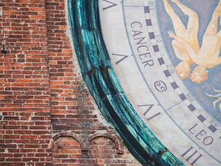 Torrazzo astrological clock detail showing Cancer zodiac sign on brick wall in Cremona, Lombardy, Italy