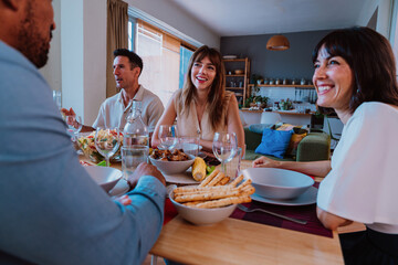 Family and friends reunion at home. Multi-generational diverse family enjoying meal and conversation