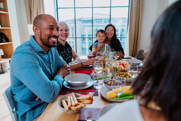 Family and friends reunion at home. Multi-generational family gathering having lunch at home