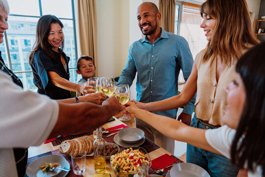 Family and friends reunion at home. Diverse family and friends celebrating together making a toast