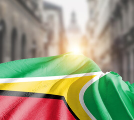 Guyana flag fluttering on blur street with building. Guyana national flag for independence day.