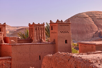 Shows details of traditional architecture. Buildings and towers of Ait ben haddou are made of clay, and stand against the backdrop of a desert landscape in Morocco.