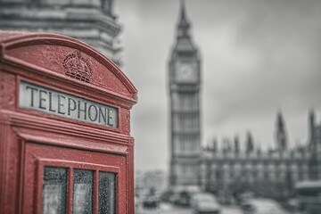 Iconic Red Telephone Box in London with Big Ben  Houses of Parliament blurred backdrop.
