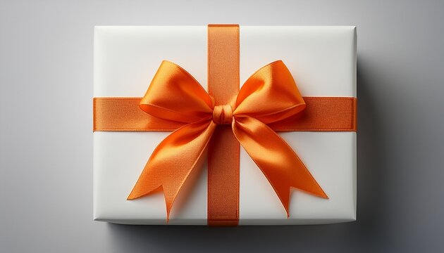A Beautifully Wrapped White Gift Box Adorned With A Vibrant Orange Bow On A Clean Surface