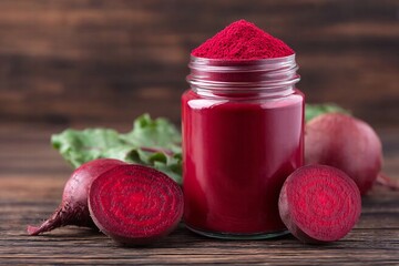 Jar of vibrant beet powder with fresh beets on rustic wooden table.