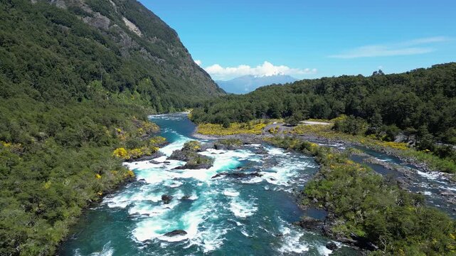 Petrohue, Chile: Aerial drone footage of the famous Petrohue river and waterfall near Puerto Varas, Lake District in Chile surrounded by forest with Calbuco volcano on a sunny day. 
