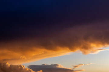 Dark cloud bank above glowing golden evening light