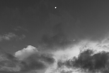 Moon above dark monotone clouds