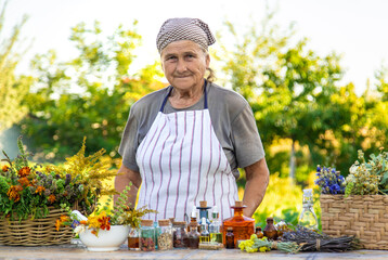 Grandmother makes tinctures from medicinal herbs. Selective focus.