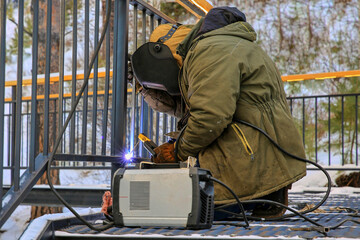 a welder installs iron structures