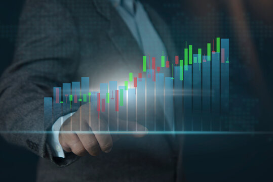 Businessman hand pointing at glowing forex chart trading interface on blurry background. invest in stock market, fund digital asset plan. Business finance technology investment concept.