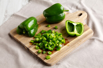 Organic Chopped Green Bell Peppers arranged on a Cutting Board, side view.