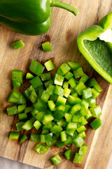 Organic Chopped Green Bell Peppers arranged on a Cutting Board, top view.