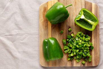 Organic Chopped Green Bell Peppers arranged on a Cutting Board, top view. Copy space.