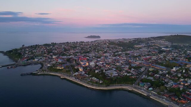 Chiloe Island, Chile: Dramatic aerial footage of sunset over Ancud housing areas, a town in Chiloe Island in Lake District of Chile. Taken with forward and tilt up motion