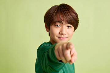 Young Asian Boy Pointing Directly at the Viewer with a Confident Expression