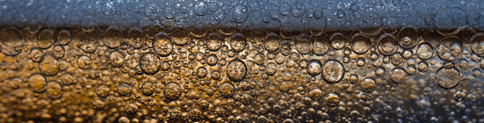 Obraz premium 4K Ultrawide Close-up of fizzy drink on glass party background - Bubbles abstract golden drink close-up