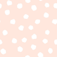 Soft pastel pink background scattered with irregular white hand drawn blot shapes. Festive dotted textured seamless pattern for textiles, stationery, wallpapers, crafts, decor, fabric, cover design.