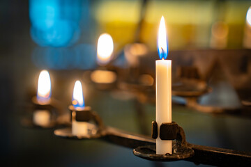weisse Opferkerzen als Zeichen der Hoffnung in einer Kirche
