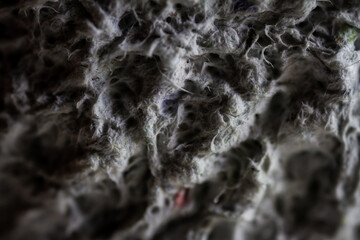 Extreme close up of old gray handmade paper clay with a structure and rough texture. Paper recycling. Selective soft focus, shallow depth of field.