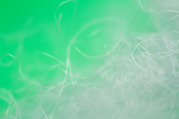 Extreme macro of polyester stable fiber on green background. Selective focus, shallow depth of field. Abstract dreamy background