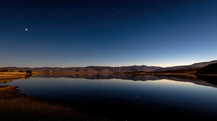 Stars Reflecting on Calm Lake Under Dark Night Sky