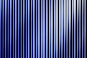 Obraz premium Abstract background of vertical blue corrugated panel texture with strong light and shadow creating a modern rhythmic pattern
