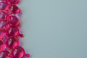 Bright pink hair capsules border on the left side of a clean light background, providing generous copy space for text, promotional cosmetic health care advertising