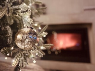 Close-Up of Christmas Ornament on Tree with Glowing Fireplace