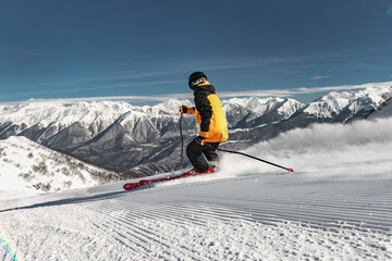 Expert skier rides at fresh ski alpine slope. Winter holidays at ski resort