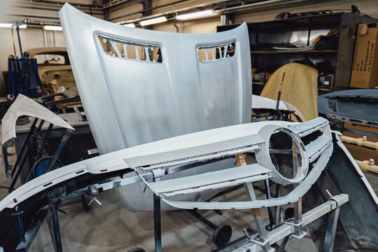 Car body shell completely disassembled after an accident in an auto service garage for major body repair and structural frame restoration work. Industrial shot for advertising and service promotion.
