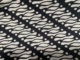 Abstract patterned textile in black and white with a repeating wavy design