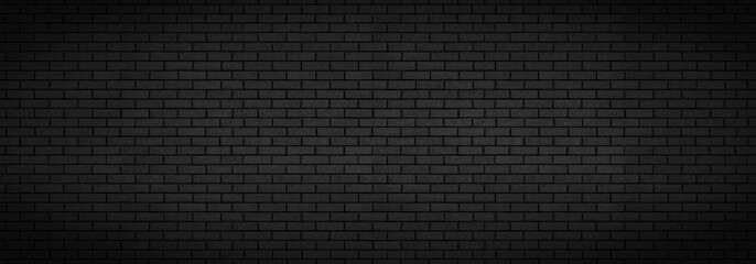 Black brick wall background texture. Dark panoramic night time city or town building design backdrop. Copy room for text.