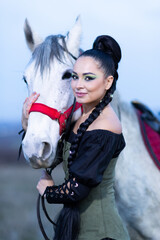 Charming European lady posing with a majestic white horse in an open field, symbolizing freedom, calmness, and connection with nature.