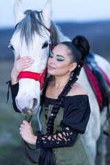 Charming European lady posing with a majestic white horse in an open field, symbolizing freedom, calmness, and connection with nature.