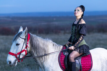 Charming European lady posing with a majestic white horse in an open field, symbolizing freedom, calmness, and connection with nature.