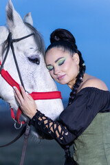 Charming European lady posing with a majestic white horse in an open field, symbolizing freedom, calmness, and connection with nature.