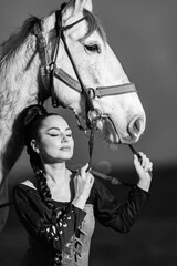 Charming European lady posing with a majestic white horse in an open field, symbolizing freedom, calmness, and connection with nature.