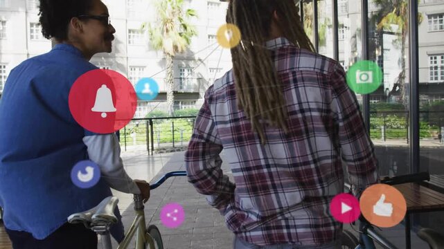 Two men pushing bikes path, right man pointing, bringing floating icons to glass window marketing