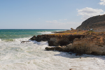 Furious storm and white foam turquoise waves crashing on rocky coast