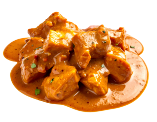 Close up of spicy meat curry in rich orange sauce with gravy splashes on isolated background